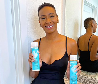 Woman with short type 4b hair holding a bottle of derma e shampoo and conditioner and smiling